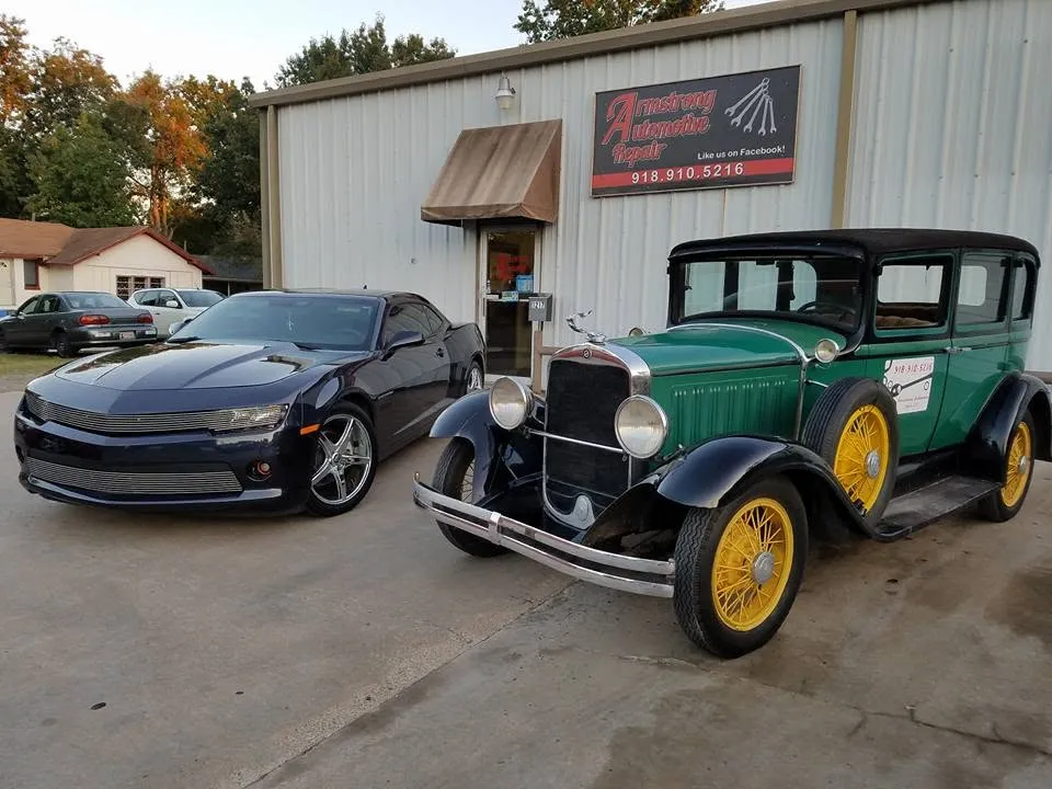 A late-model Camaro and a restored 1930s sedan parked in front of the Armstrong Automotive Repair shop on Gibson Street